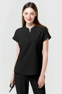 Model wearing Jet Black CST202 Scrub Top in a clinical setting, three-quarter view from front