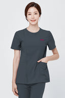 Model wearing Deep Slate Mild280 Zip Scrub Top in a studio setting, three-quarter view