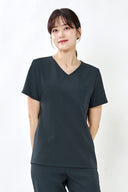 Model wearing Charcoal ST002 Scrub Top in a studio setting, three-quarter view