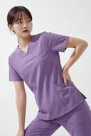 Model wearing Lavandula ST215 Scrub Top in a studio setting, three-quarter view