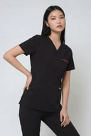 Model wearing Black ST247 Scrub Top in a studio setting, three-quarter view
