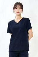 Model wearing Stellar Navy ST002 Scrub Top in a studio setting, three-quarter view