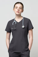 Model wearing Grey CST203 Scrub Top in a studio setting, three-quarter view