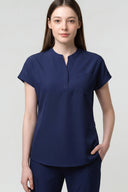 Model wearing Warm Navy CST202 Scrub Top in a clinical setting, three-quarter view