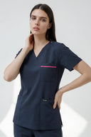 Model wearing Navy ST247 Scrub Top in a studio setting, three-quarter view