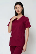 Model wearing Rosé Wine Avison Scrub Top in a clinical setting, three-quarter view