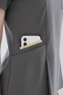 Pocket, neckline and seam details on the Mild Grey Anyone Zip Scrub Top from the side