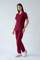 Model wearing Rosé Wine Avison Scrub Top by Good Uniform, full front view slightly from the side