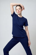 Warm Navy CST201 Scrub Top shown during movement to demonstrate fit and flexibility three-quarter shot