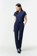 Model wearing Warm Navy CST202 Scrub Top by Good Uniform, full front view