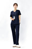 Model wearing Stellar Navy ST002 Scrub Top by Good Uniform, full front view