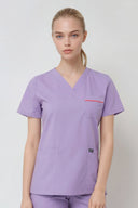 Model wearing Lavandula ST247 Scrub Top in a studio setting, three-quarter view