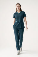 Model wearing Antique Blue Anyone Zip Scrub Top by Good Uniform, full front view