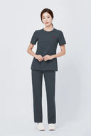 Model wearing Deep Slate Mild280 Zip Scrub Top by Good Uniform, full front view