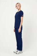 Model wearing Indigo Blue Mild280 Zip Scrub Top by Good Uniform, full side view