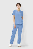 Model wearing Reef Blue ST002 Scrub Top by Good Uniform, full front view