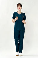 Model wearing Turkey Green ST002 Scrub Top by Good Uniform, full front view
