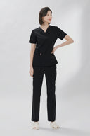 Model wearing Black Avison Scrub Top by Good Uniform, full front view