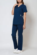 Model wearing Matte Blue Avison Scrub Top by Good Uniform showing functional pockets, full front view