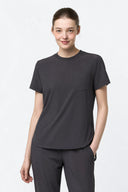Model wearing Grey CST201 Scrub Top in a studio setting, three-quarter view