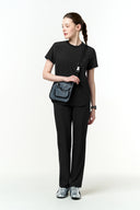Model wearing Jet Black CST201 Scrub Top by Good Uniform, full front view
