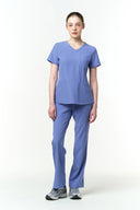Model wearing Lavender Blue CST203 Scrub Top by Good Uniform, full front view