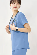 Model wearing Reef Blue ST002 Scrub Top in a studio setting, three-quarter view from the side