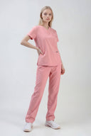 Model wearing Indi Pink ST247 Scrub Top by Good Uniform, full front view slightly from the side