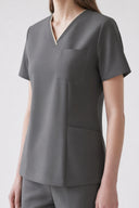 Pocket, neckline and seam details on the Mild Grey Anyone Zip Scrub Top