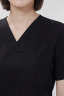 Pocket, neckline and shoulder details on the Black Avison Scrub Top