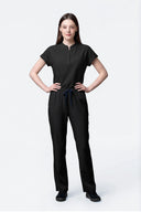 Model wearing Jet Black CST202 Scrub Top by Good Uniform, full front view