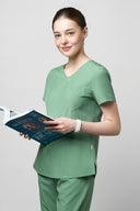Model wearing Smoke Mint CST203 Scrub Top in a studio setting, three-quarter view slightly from the side