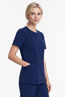 Model wearing Indigo Blue Mild280 Zip Scrub Top by Good Uniform, three-quarter side view