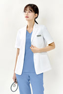 Model wearing Reef Blue ST002 Scrub Top with half-sleeve medical jacket, three-quarter view