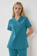 Model wearing Aquamarine ST215 Scrub Top in a studio setting, three-quarter view from the front