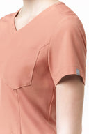 Pocket, neckline and seam details on the Coral Peach CST203 Scrub Top from the side
