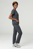 Model wearing Deep Slate ST247 Scrub Top by Good Uniform, full side view