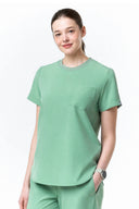 Model wearing Smoke Mint CST201 Scrub Top in a studio setting, three-quarter view