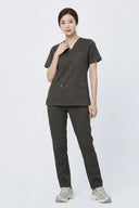Model wearing Burnt Brown Avison Scrub Top by Good Uniform, full front view 