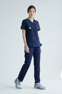 Modern Navy Avison Scrub Top shown during movement to demonstrate fit and flexibility from the side