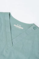 Vintage Mint Avison Scrub Top by Good Uniform showing neckline and shoulder button in flat-lay shot.